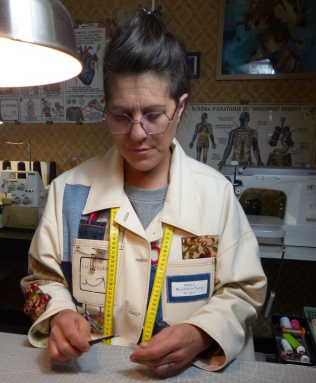 Portrait de Laure, couturière et créatrice de la marque Lo Reboto, concentrée sur la confection d'une veste upcyclée à partir d'une couverture vintage.